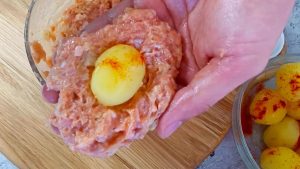 Eva Vahovich rikkoo munat lihaan ja heittää ne paistinpannulle. Sata kertaa parempaa kuin jauhelihamykyjä.