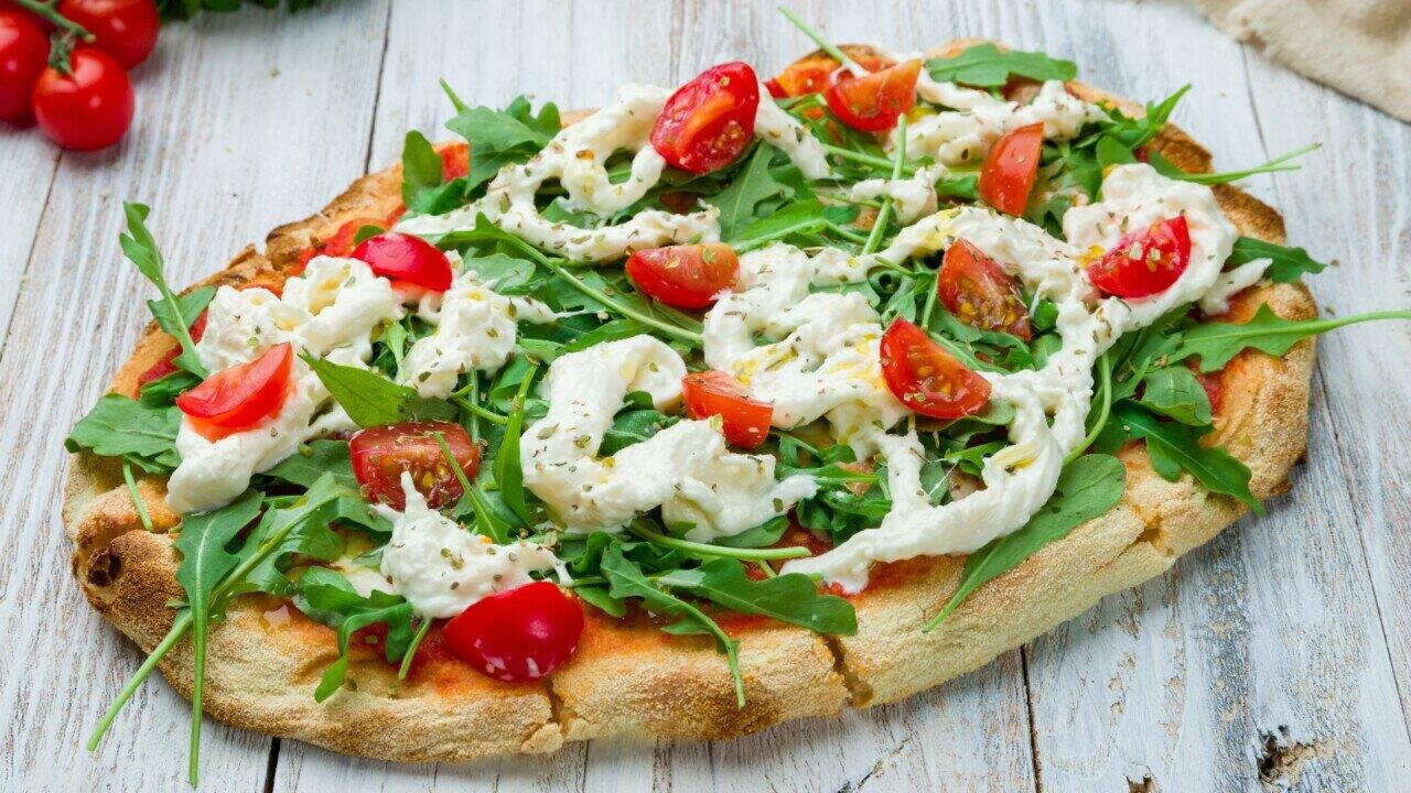 Pinsa burratalla: rapea kuori, tuoreet tomaatit ja pesto – suoraan uunista.