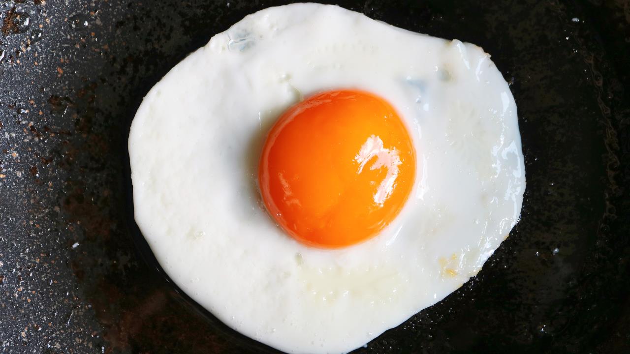 Miksi on suositeltavaa lisätä etikkaa pannulle munia paistaessa, ja mikä on sen tarkoitus?