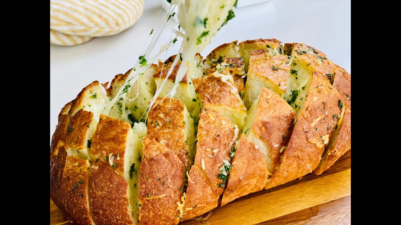 Valkosipulileipä, valmistettu hiivataikinasta – kullanruskea ulkopuolelta, pehmeä ja mureneva sisältä.