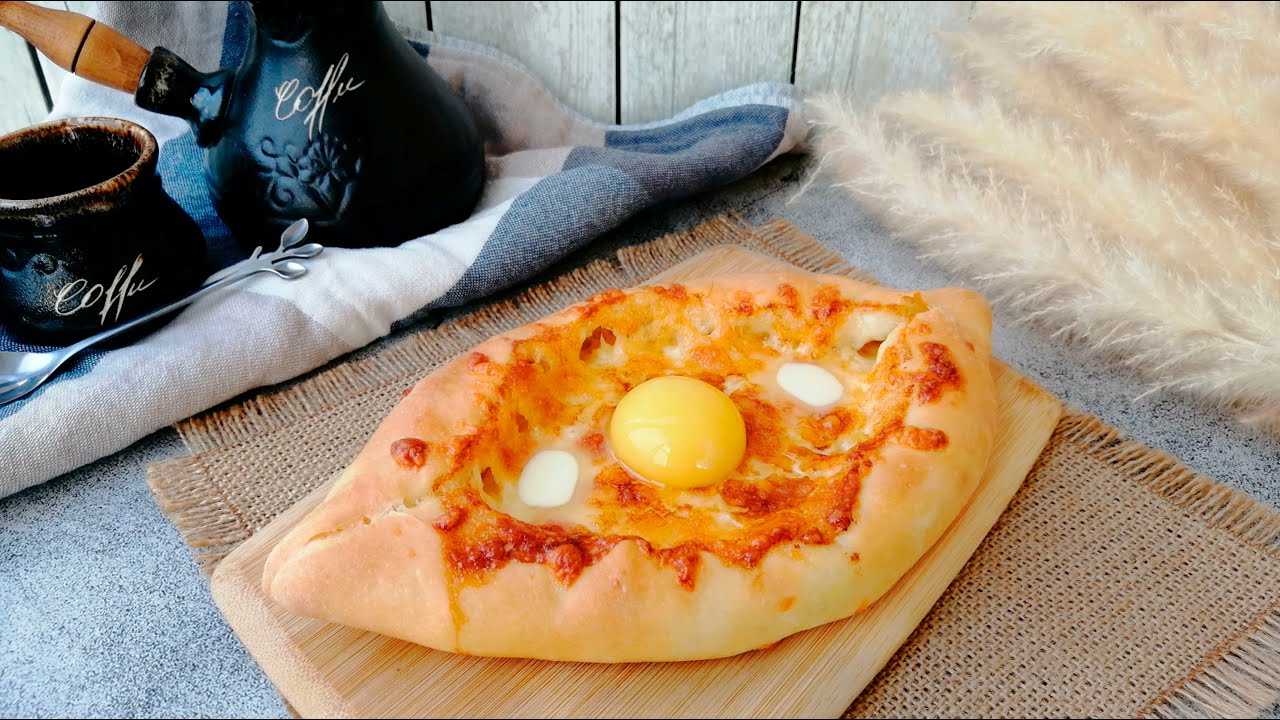 Hiivaleipä, joka on täytetty herkullisella juustolla ja munankeltuaisella. Valmista khachapuri samalla tavalla kuin se tarjoillaan georgialaisessa ravintolassa.