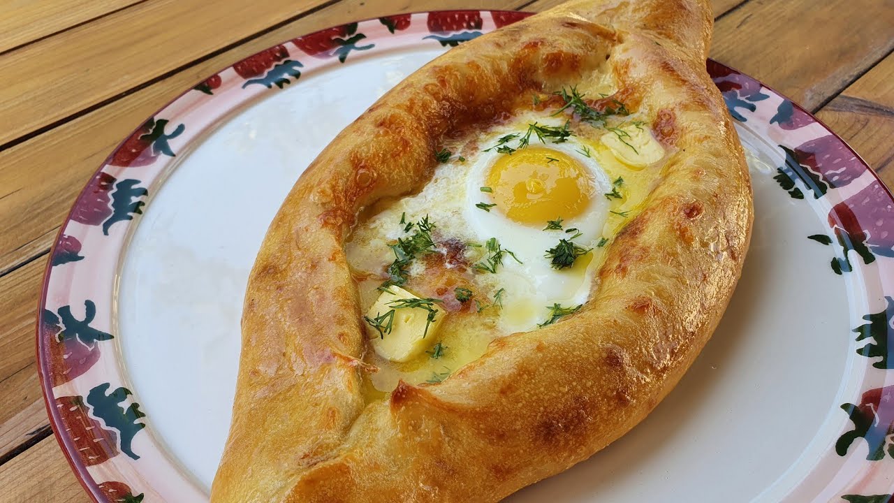 Hiivaleipä, joka on täytetty herkullisella juustolla ja munankeltuaisella. Valmista khachapuri samalla tavalla kuin se tarjoillaan georgialaisessa ravintolassa.